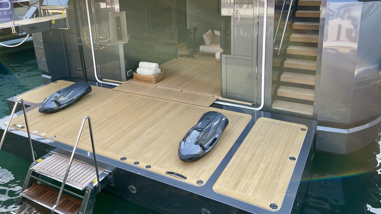 Two underwater scooters on the teak swim platform of a yacht