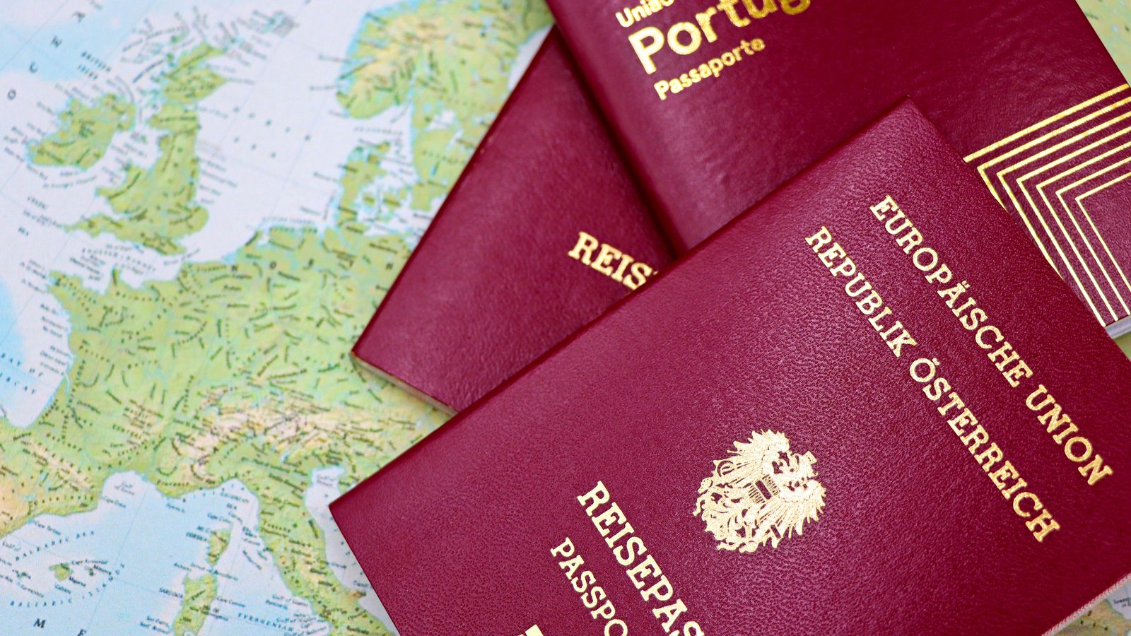 Several European passports lying on a map of Europe